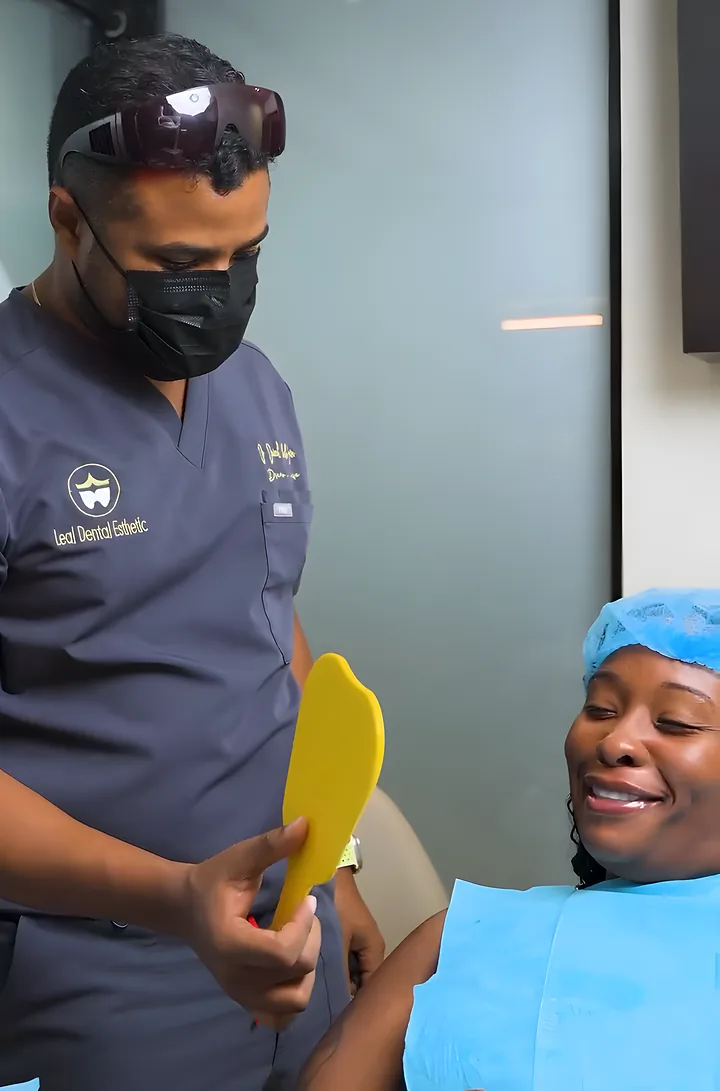 Dr. Daniel hands a mirror to a patient